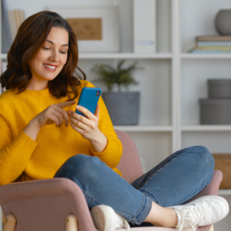 A woman relaxing on a seat and using her phone