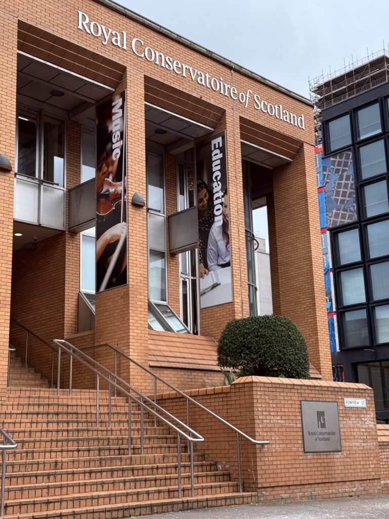 An image of the Royal Conservatoir of Scotland in Glasgow. It has red bricks, and a staircase with metal hand rails.